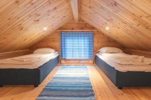 穆奥尼奥Harriniva Adventure Resort Cabins的阁楼间设有两张床,设有窗户