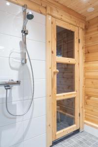 穆奥尼奥Harriniva Adventure Resort Cabins的木制浴室内带玻璃门的淋浴
