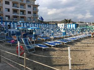 因佩里亚Soggiorno Marino San Giuseppe的沙滩上的一把椅子和遮阳伞