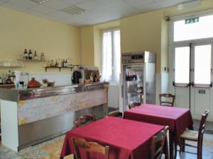 因佩里亚Soggiorno Marino San Giuseppe的一间带2张桌子的餐厅以及一个带柜台的厨房