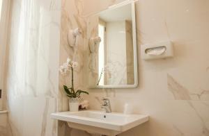 罗马帕拉蒂姆宫酒店的白色的浴室设有水槽和镜子