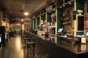 卡卡韦洛斯Hostal Siglo XIX的餐厅内拥有绿色墙壁和凳子的酒吧