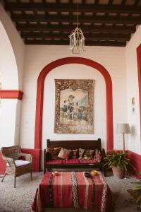 赫雷斯-德拉弗龙特拉拉卡雷尼娜乡村民宿的卧室配有一张床,墙上挂有绘画作品
