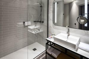 波兹南波兹南中心美居酒店的一间带水槽、镜子和淋浴的浴室