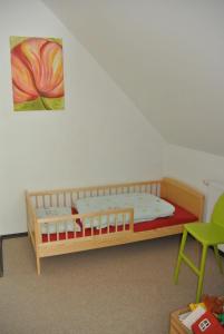 HipstedtFEWO Elbe Weser的一间卧室配有木床和绿色椅子