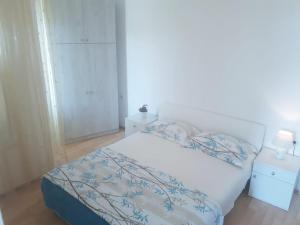 拉斯托伏Apartments Hropić的一间卧室配有一张白色的床和蓝色的毯子