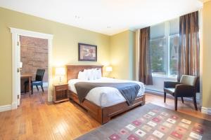 魁北克市格林奥乐酒店的卧室配有一张床、一张桌子和椅子