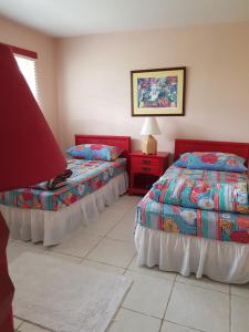 自由港市Bajamar Your Second Home Guest Property的一间卧室配有两张床和一张带台灯的桌子