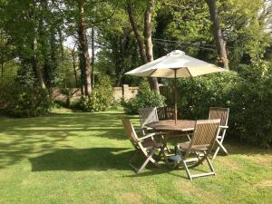 克劳利Tanglewood Gatwick Bed & Breakfast的院子里的桌椅和雨伞