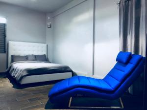 阿瓜迪亚Modern Suite #0 - best location的一间卧室配有蓝色椅子和一张床