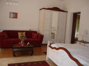 Csepreg老磨坊酒店的客厅配有床和红色沙发