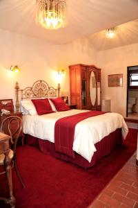 苏克雷苏默塞德埃尔旅馆的一间卧室配有一张大床,铺有红地毯