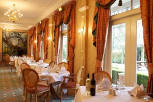 克罗伊登Coulsdon Manor Hotel and Golf Club的用餐室设有桌椅和窗户。
