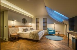 维尔纽斯Hotel Vilnia的一间卧室配有一张床和一张蓝色椅子