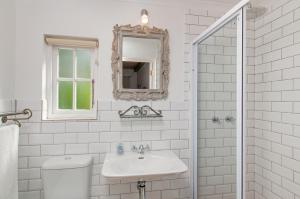 斯韦伦丹Hotel Roosje van de Kaap的白色的浴室设有水槽和镜子