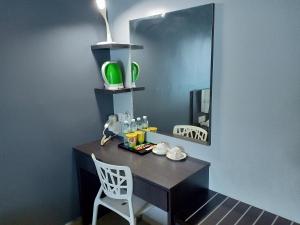 瓜埠G Langkawi Motel的一张带镜子和白色椅子的黑色书桌