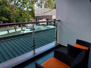 瓜埠G Langkawi Motel的阳台配有两把椅子和浴缸。