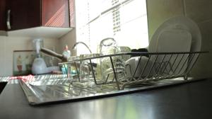 哈博罗内Tap's Home Away from Home的厨房柜台上装满碗碟的碗架