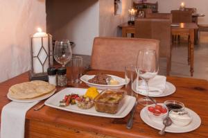 斯韦伦丹Hotel Roosje van de Kaap的木桌,带食物和酒杯盘