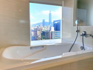 台北怡品商旅的带浴缸的浴室和窗户