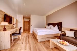纳图尔诺拉姆酒店的一间卧室配有一张床、一张沙发和一张桌子