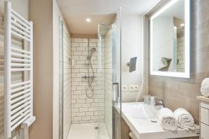 布鲁塞尔Appart'City Confort Bruxelles Centre Gare du Midi的带淋浴和盥洗盆的白色浴室