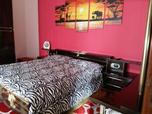兰达佐La Romantica的一间卧室配有一张床和粉红色的墙壁