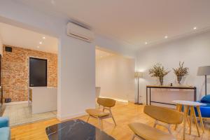 马德里Luxury Rooms Madrid Center的客厅配有椅子、桌子和电视