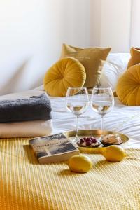 华沙Tamka Chopin Apartment的两杯葡萄酒和床上的一本书