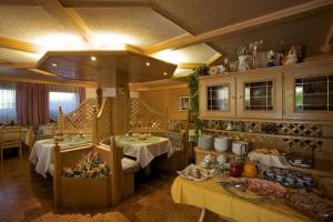 卡拉诺艾尔伯格贝拉利雅酒店的一间设有两张桌子的餐厅,房间提供食物