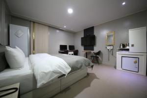 清州市Xian Hotel的卧室配有白色的床和书桌