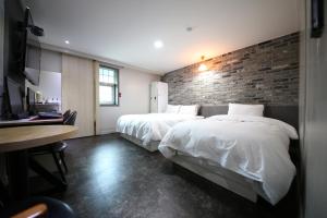 清州市Xian Hotel的酒店客房带两张床和砖墙