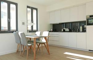 巴贝Baabe Villa Andrea Ferienwohnung M的厨房配有白色橱柜和桌椅
