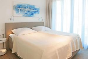 巴贝Baabe Villa Andrea Ferienwohnung M的一间卧室配有一张带白色毯子的床