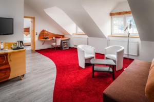 帕绍帕绍沃弗酒店的客厅配有红地毯和白色椅子