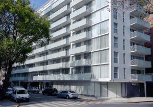 布宜诺斯艾利斯Dazzler by Wyndham Polo的一座白色的大建筑,前面有汽车停放
