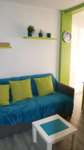 帕斯底拉卡萨孔苏埃格拉公寓的客厅配有一张蓝色的沙发,配有一张桌子