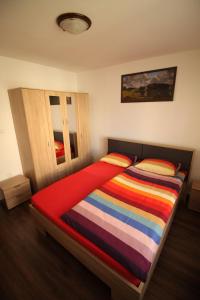 普雷代亚尔Orion的一间卧室配有一张带彩色条纹毯子的床