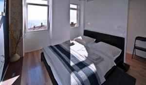 里耶卡Aurora Apartment的一张大床,位于带两个窗户的房间
