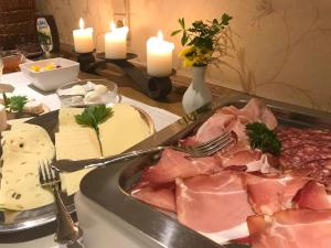 施马伦贝格Pension und Ferienwohnung Schütte的一张桌子,上面放着一盘带肉和蜡烛的食物