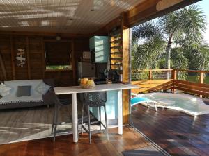 DouvilleBUNGA-LODGE (bungalow 4* avec piscine privée)的厨房配有带桌椅的甲板