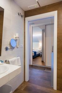 佩尼斯科拉Hotel Boutique Barra Alta (Adults Only)的一间带水槽和镜子的浴室以及一张床