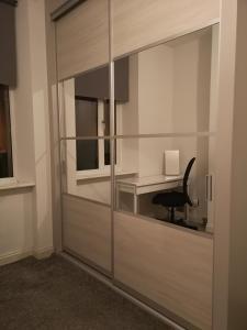 格拉斯哥Sleep Well Apartment的带玻璃隔板和书桌的房间
