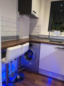 格拉斯哥Sleep Well Apartment的厨房配有洗衣机和柜台。
