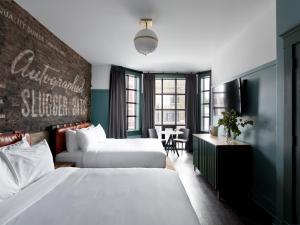 芝加哥The Chicago Hotel Collection Wrigleyville的酒店客房设有两张床和一张桌子。