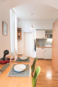 卢布尔雅那Ella's River Apartment的厨房以及带桌椅的用餐室。