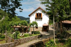 伊萨尔苏Hotel Rural Besaro - Selva de Irati的白色的房子,设有窗户和石墙