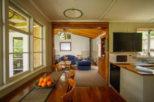 TinirotoMahaanui Cottage Farmstay的厨房以及带橙色桌子的客厅。