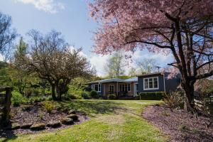 TinirotoMahaanui Cottage Farmstay的院子里有花树的房子