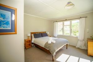 TinirotoMahaanui Cottage Farmstay的一间卧室设有一张大床和一个窗户。
